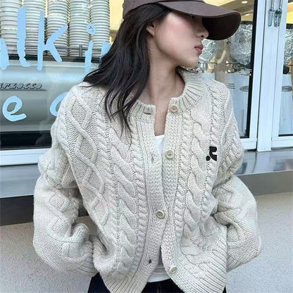 Women's chunky knit cardigan with elegant cable design and unique button details NOVAE