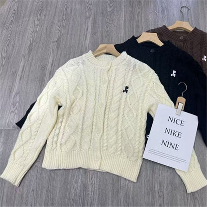 Women's chunky knit cardigan with elegant cable design and unique button details NOVAE