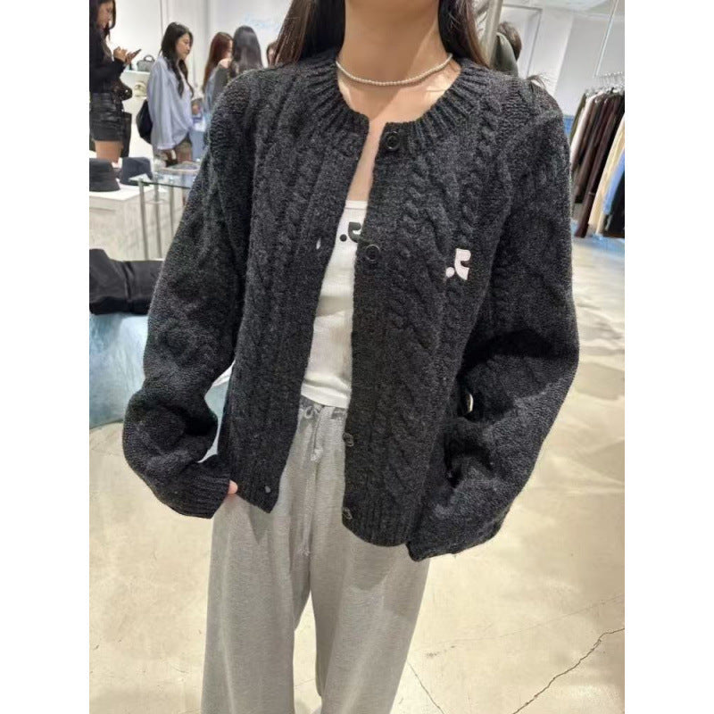 Women's chunky knit cardigan with elegant cable design and unique button details NOVAE
