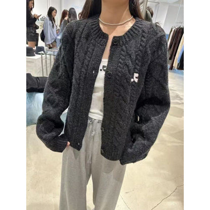 Women's chunky knit cardigan with elegant cable design and unique button details NOVAE